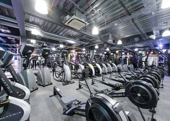 Pure-gym-manchester A gym floor in Manchester with exercise bikes in a roiw