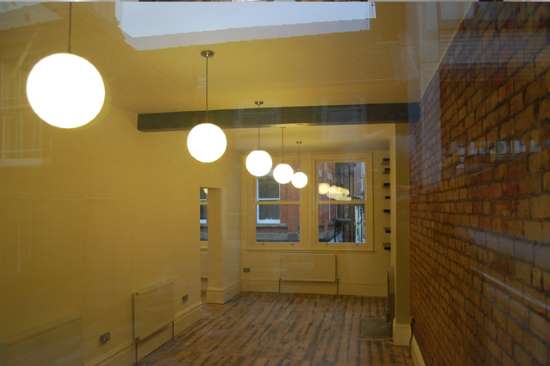 Re-fitted office space in Manchester with yellow walls and feature lighting