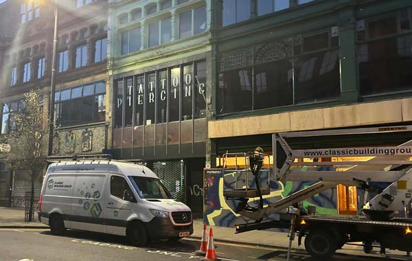 a daylight image of the exterior of the Freemount on Manchester's Oldham street, there is a classic building group van and elevation platform outside